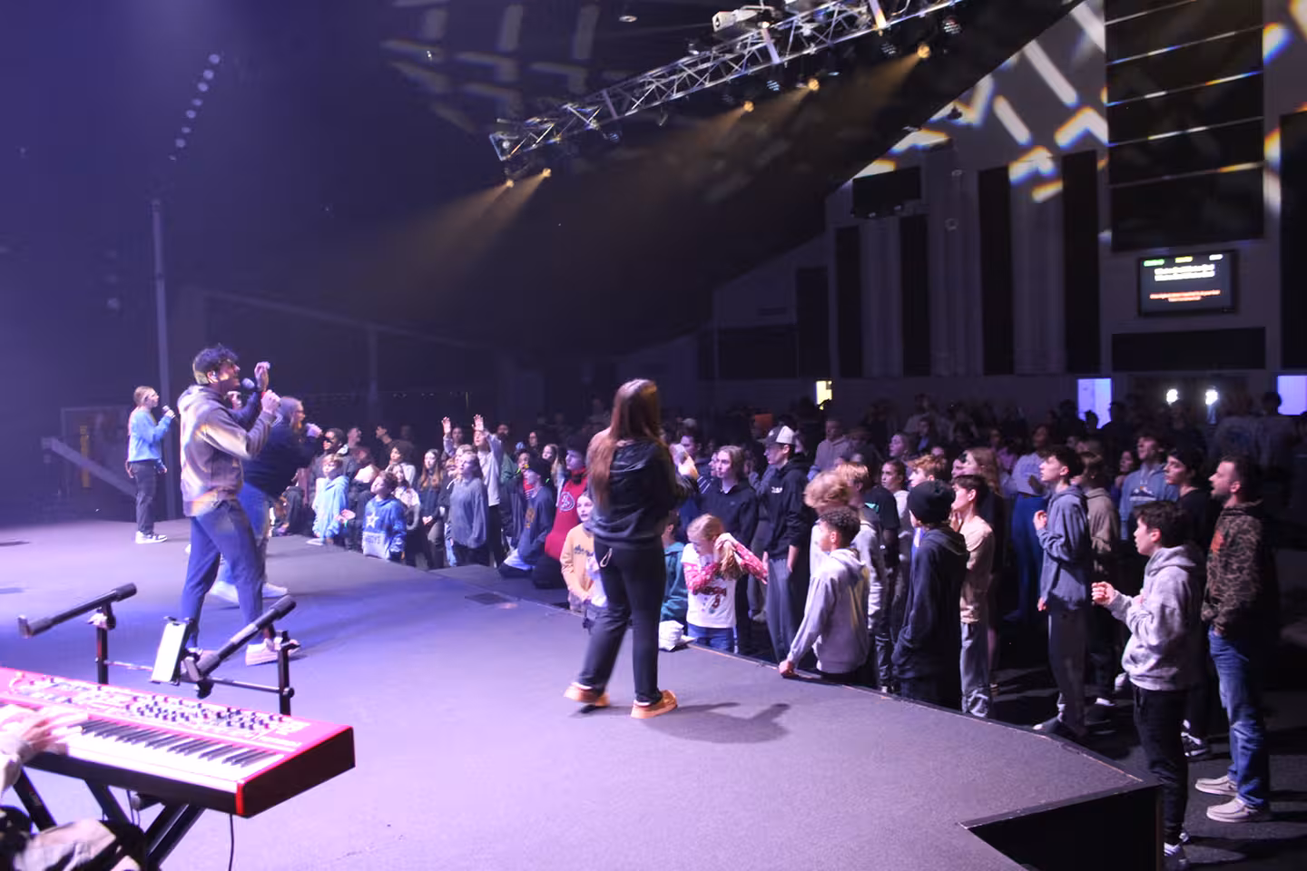 Singer on stage with crowd of people singing